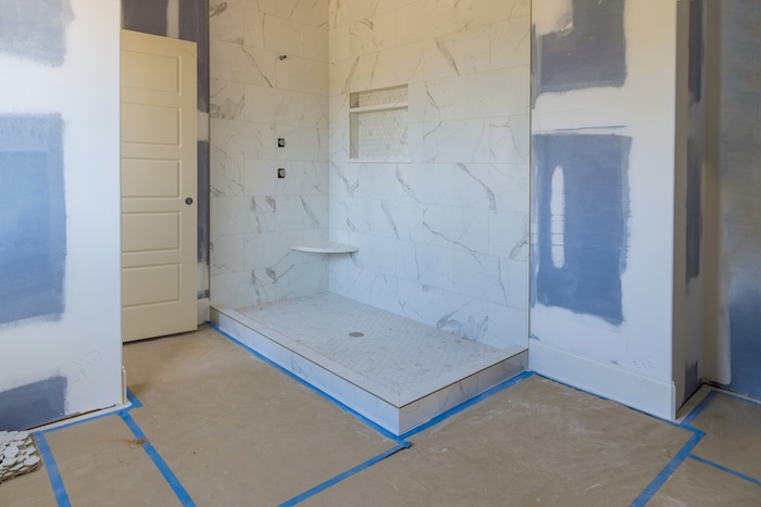 Renovation construction of master bathroom with new under construction bathroom interior drywall ready for tile in new luxury home